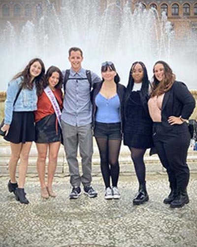 Alyssa Rodello, second from left, wears a happy birthday sash in Spanish with fellow Spring 2021 Study Abroad students near a Plaza de España fountain.