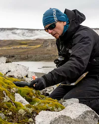 Researcher collecting black moss in the Antarctic